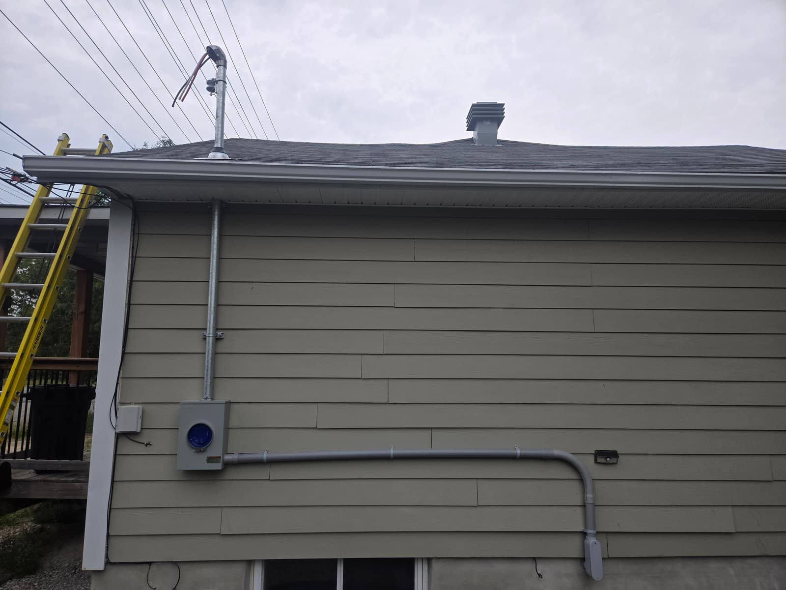 A newly installed electrical service mast and meter base on a Greater Sudbury home